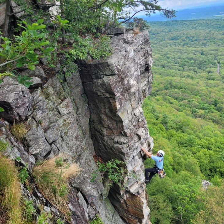A climber on a verdant arete