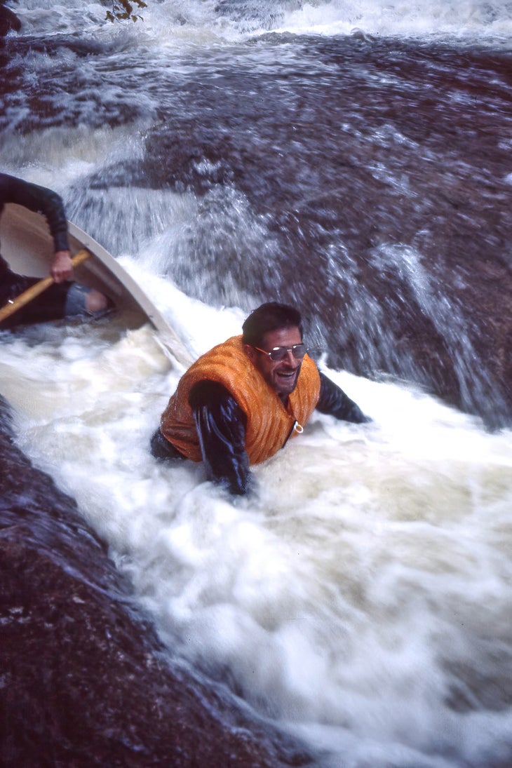 Burt Angrist getting swamped trying to take a canoe down some heavy duty river rapids.
