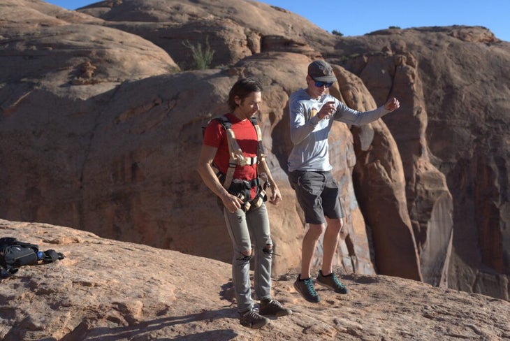 2 men jumping on rock