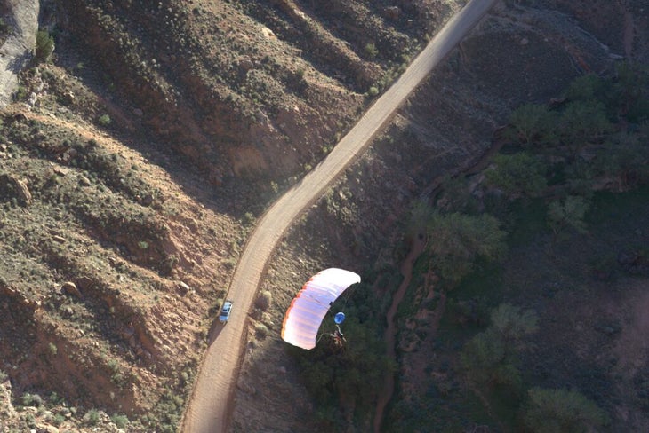A parachute flying over a dirt road