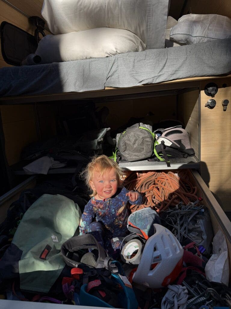 a toddler sitting in a cubby in a van 