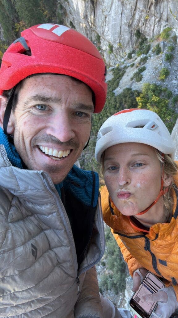 a male and female climber smiling at the camera 