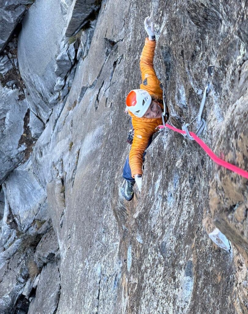 a woman in a yellow jacket climbing 