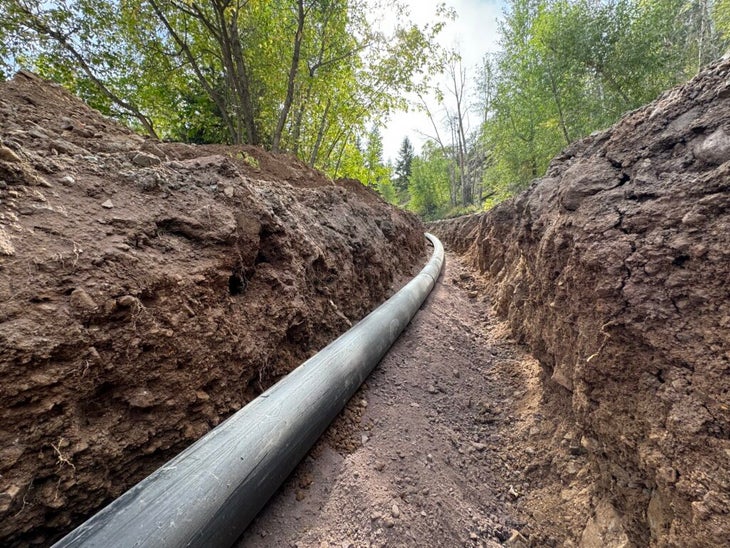 a pipeline laid into a hole in dirt