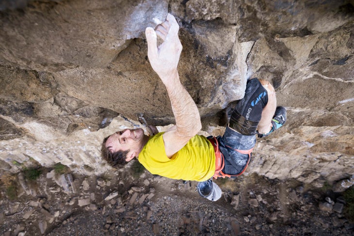 A man climbing in a yellow shirt