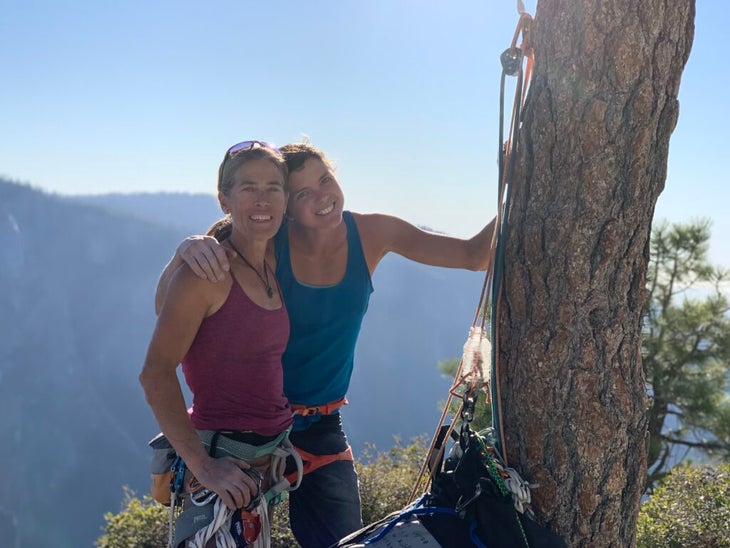 Two women standing on the summit of a climb