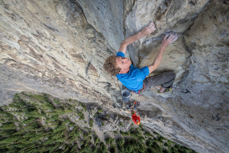A man climbing a cliff shot from above