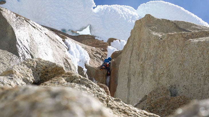 The author tops out an offwidth, with Torre Egger’s wild rime-ice tubes looming above.