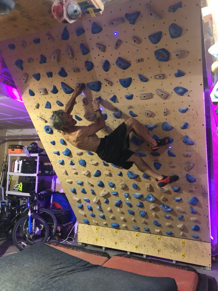 a man bouldering on a moonboard