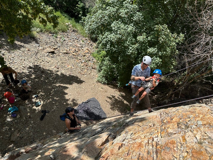 a woman belaying a man and child