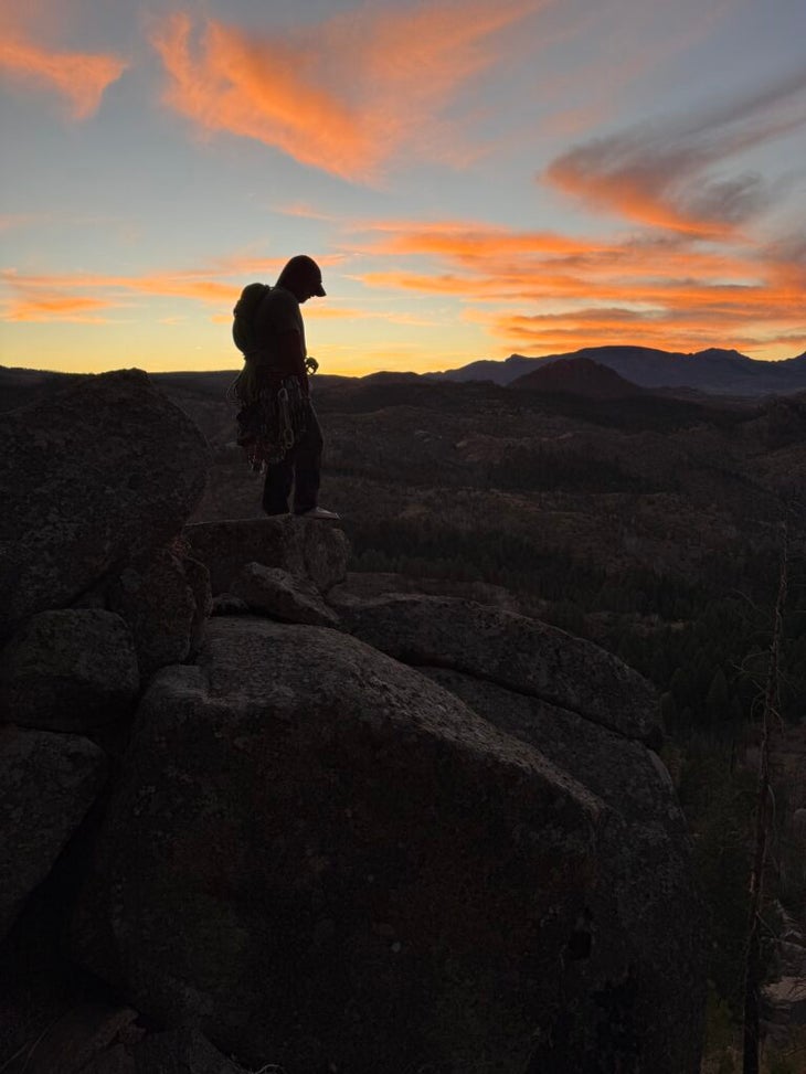 man standing on a rock in the sunset
