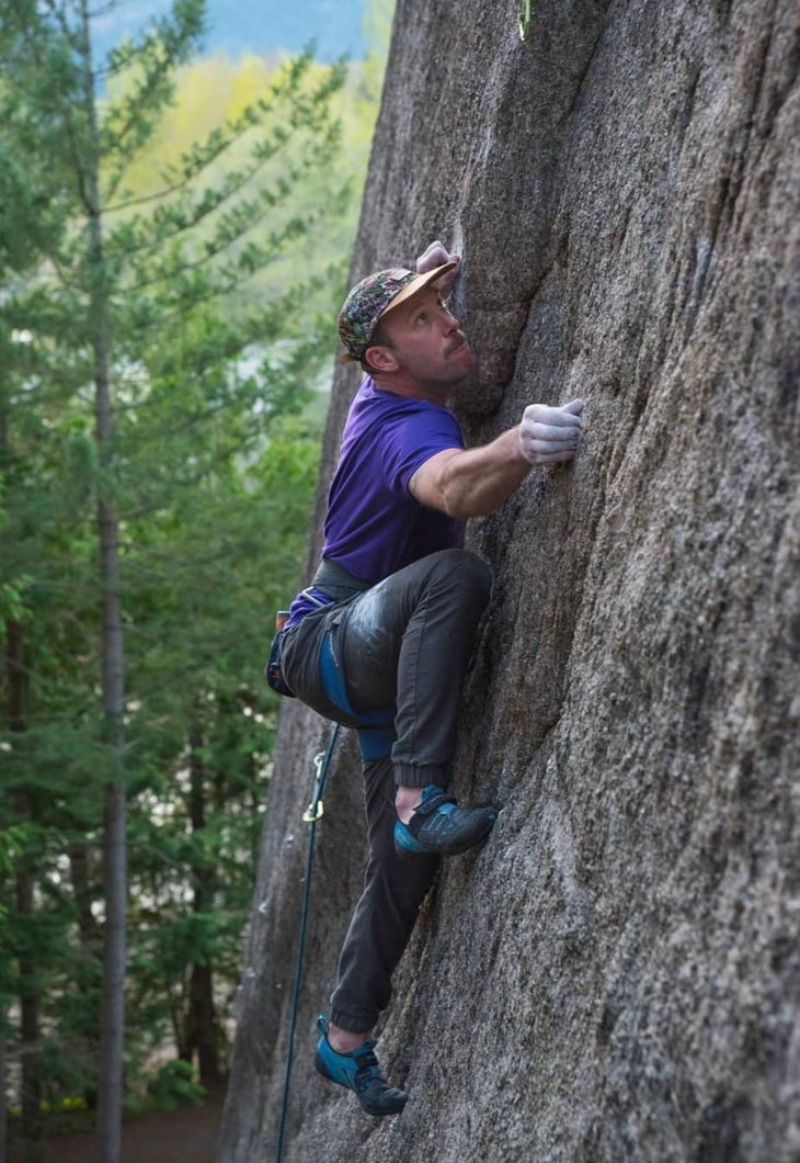 man climbing in purple shirt
