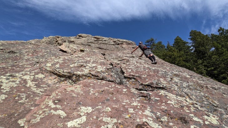 a man scrambling up the rock