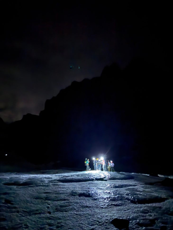 Volunteers carry a stretcher in the dark.