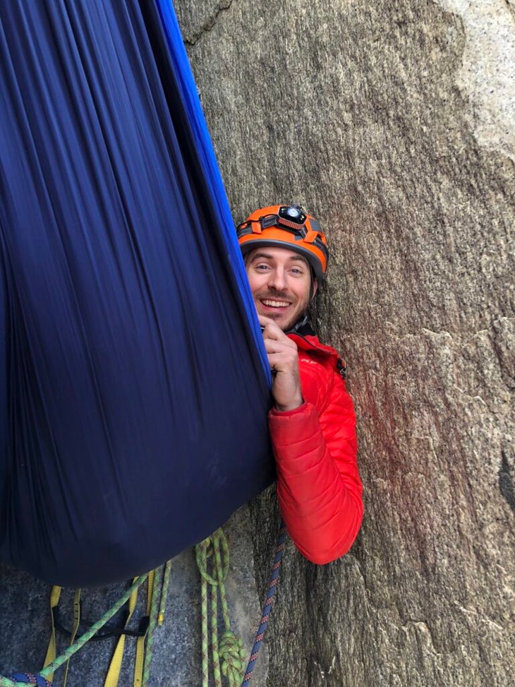 a climber in a hammock on the wall