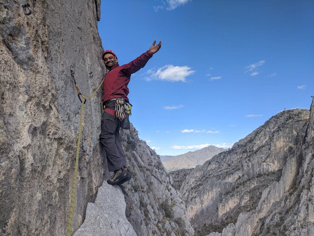 a man climbing on a cliffband 