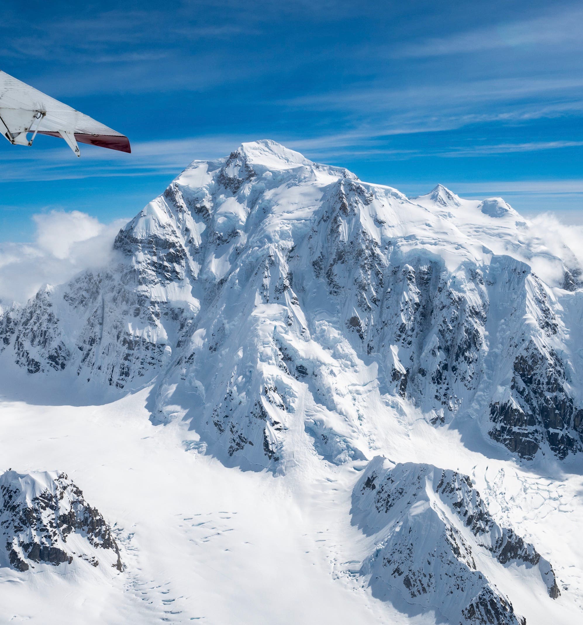 A very snowy Begguya (photo taken from previous season) with the prominent North Buttress directly below the plane's wingtip.