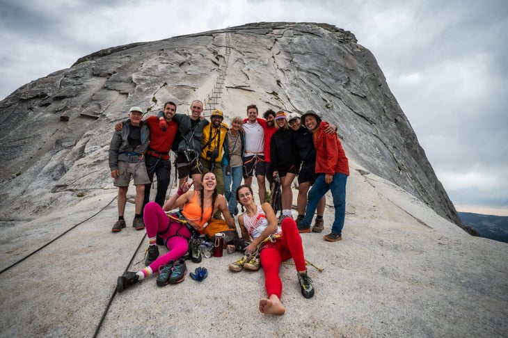 a group of people atop half dome