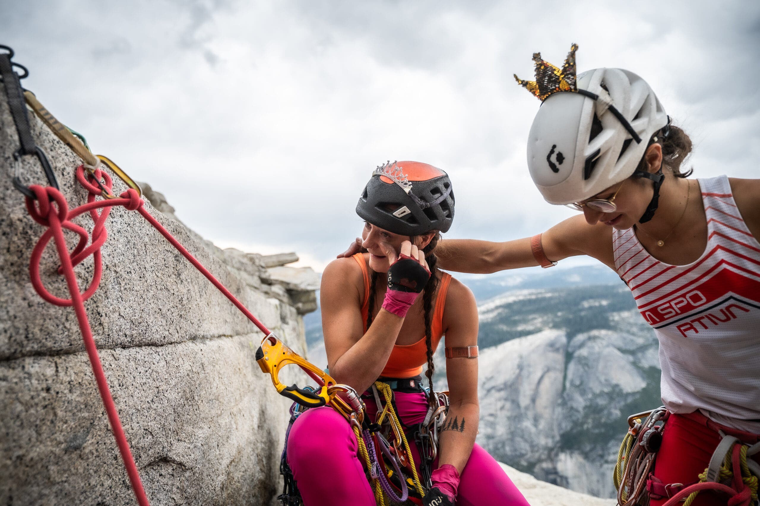 a woman crying at the top of a climb