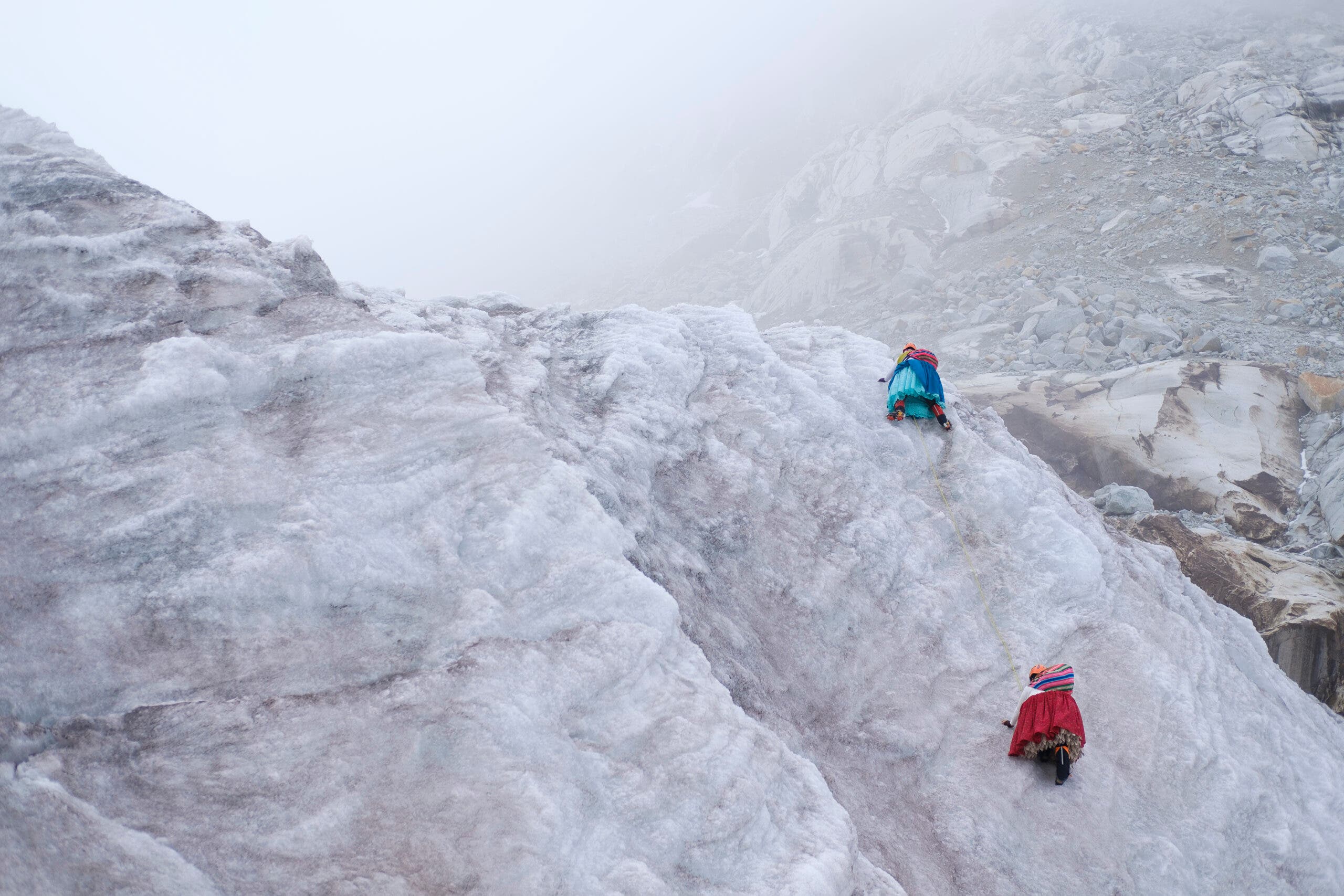 climbing cholitas climbing a snowfield in bolivia