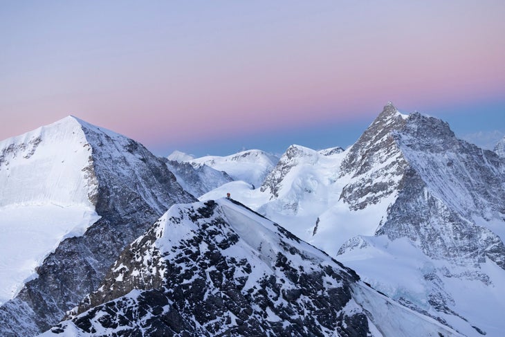 Nicolas Hojac and Philipp Brugger on the Eiger's summit with the Moench and Jungfrau north faces in the background.