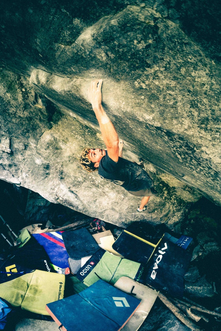 Climber crimps on small holds below V15 boulder in Europe.