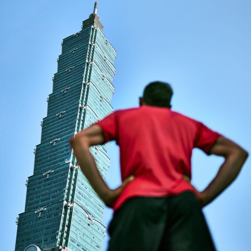 alex Honnold looking at Taipei 101 in Taiwan