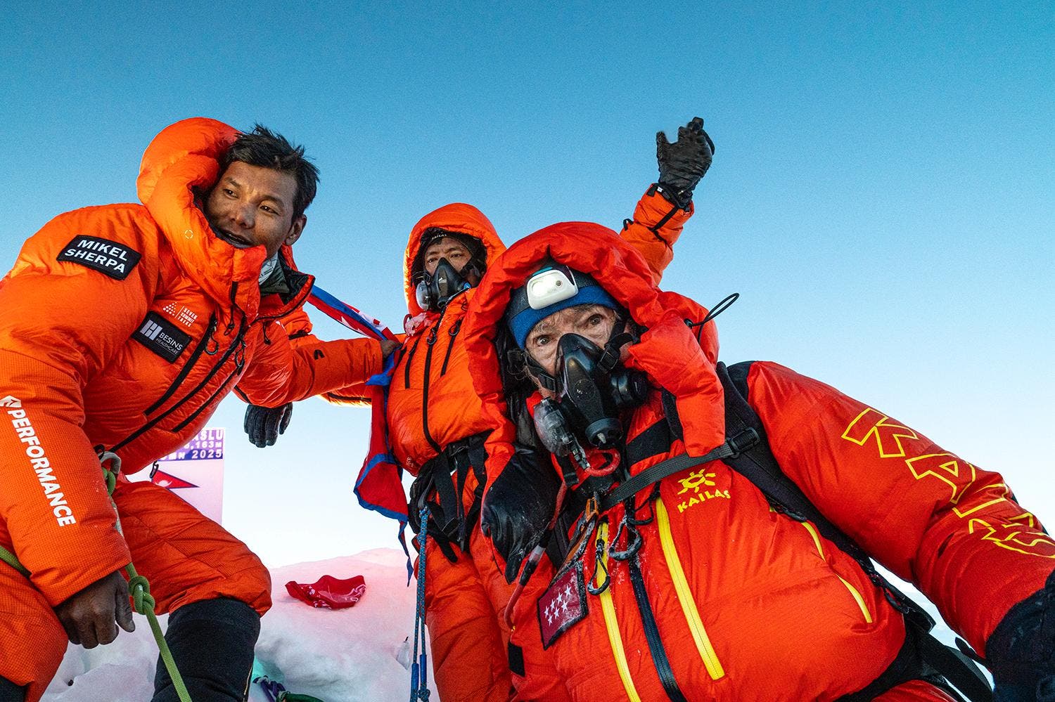 carlos soria and two other climbers standing atop manaslu