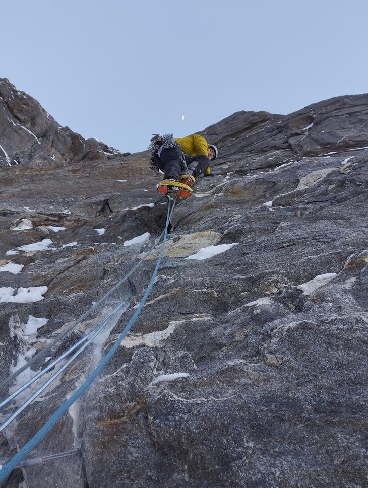 Climbers ascends vertical crack of granite while making a major first ascent of the peak.