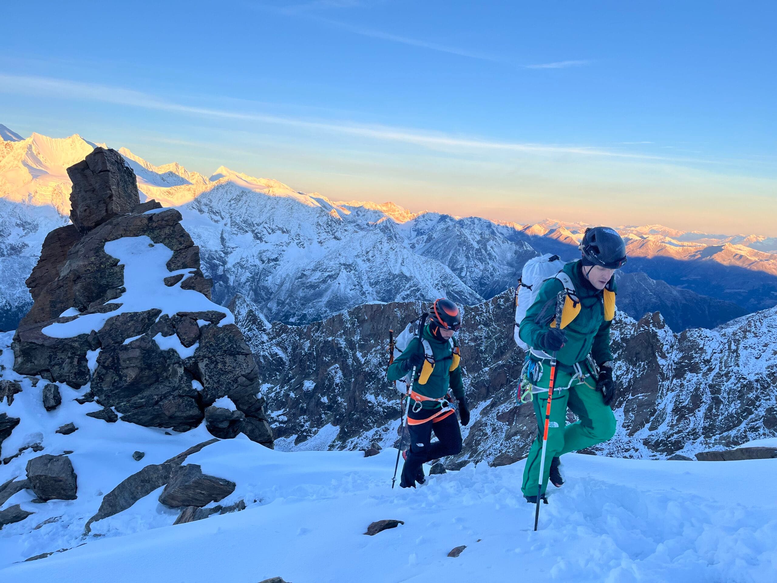 Two alpinists carry the AMK pack in Switzerland's snowy mountains.