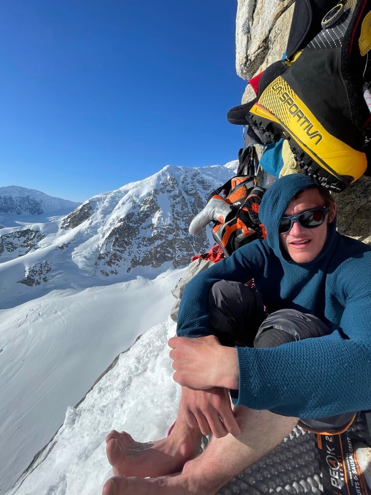 Balin Miller drying his feet at the first ice band bivy on the North Buttress of Mt. Hunter/Begguya, Alaska.