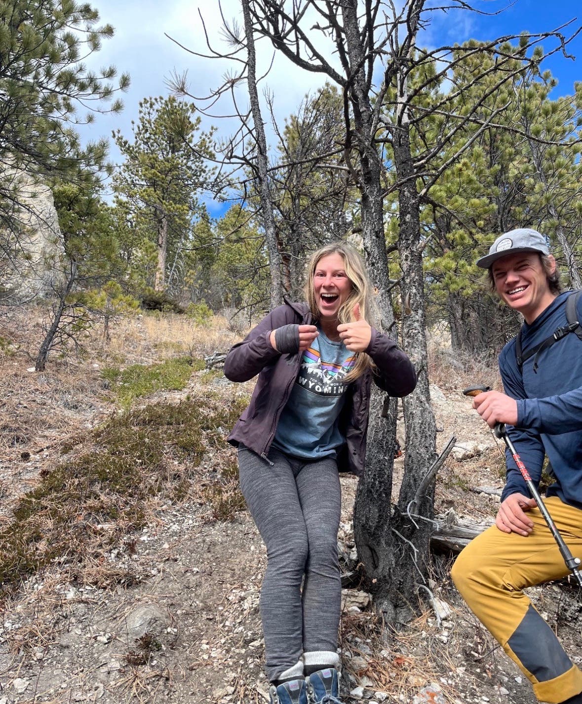 Mylee Lorenz (left) poses with her thumb wrapped in a piece of Ayla McNeilley's t-shirt. Her friend, Dustin Kisner (right), smiles next to her.