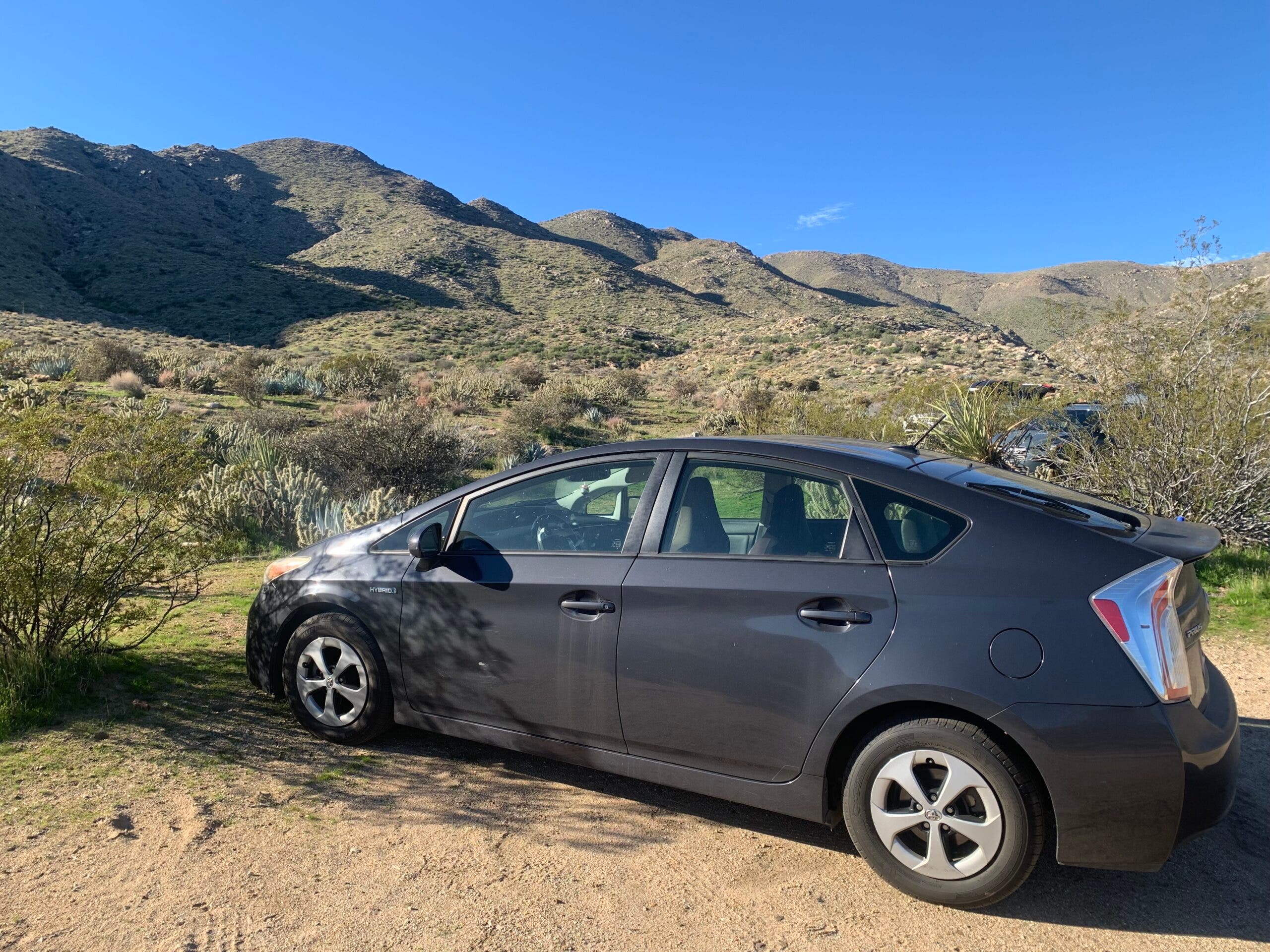 A Toyota Prius parked in a dirt lot. This is one of the most underrated dirtbag vehicles for climbers.