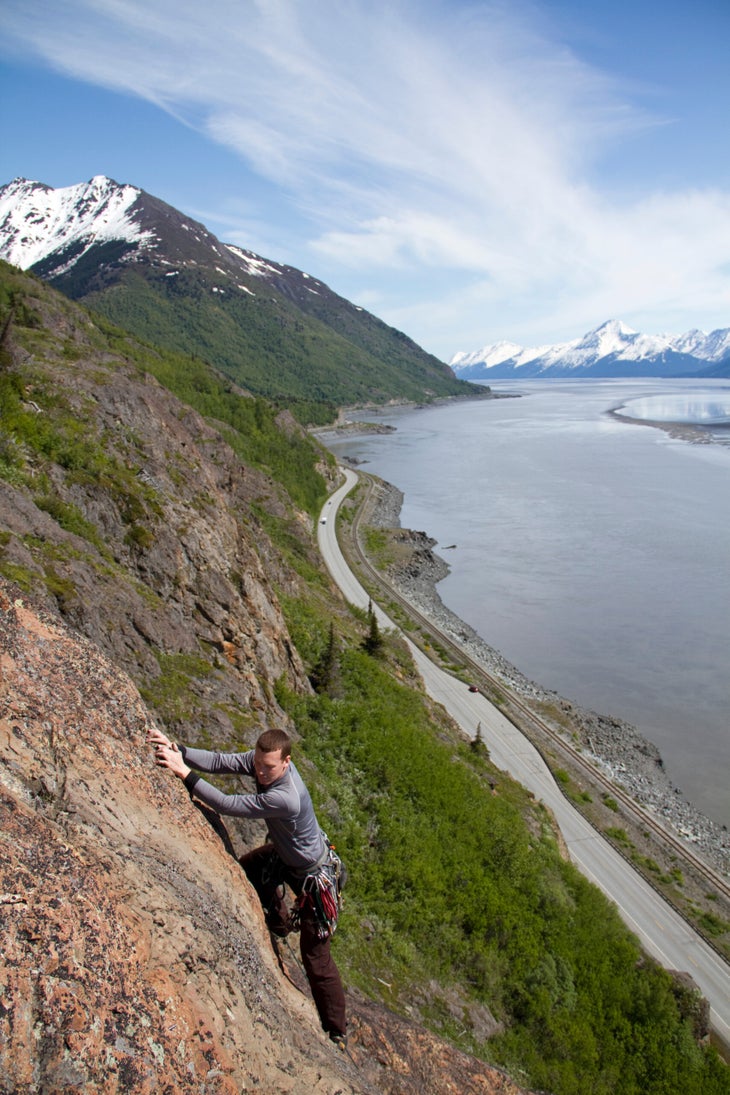 John Borland climbs 'Sunshine Ridge' (5.7), with the Seward Highway visible beneath.
