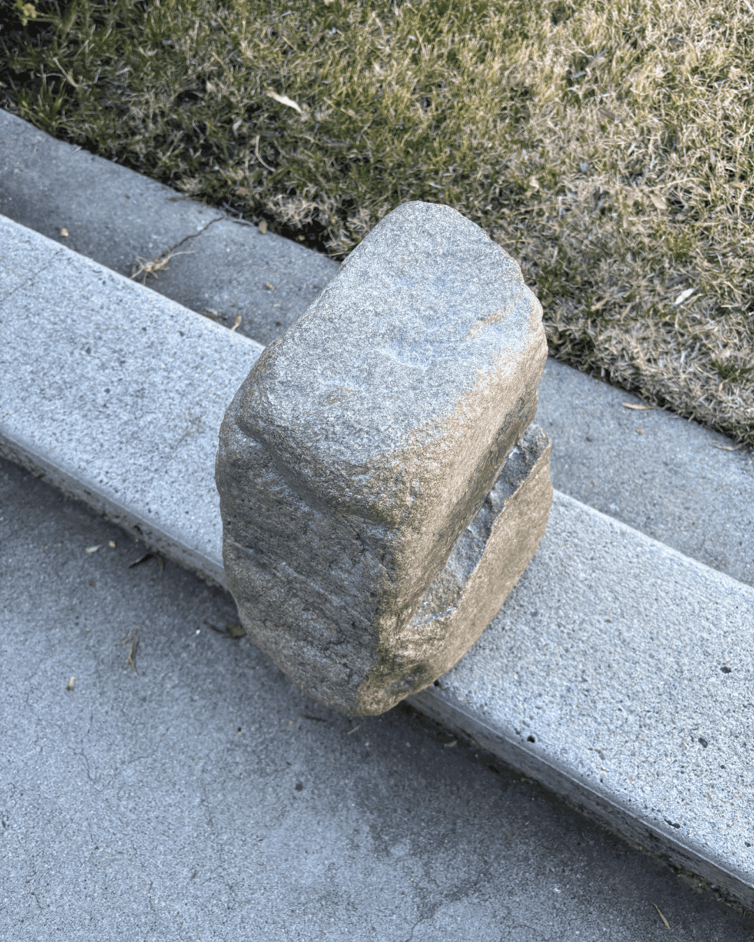 The 70-pound rock called Portable on a roadside curb.