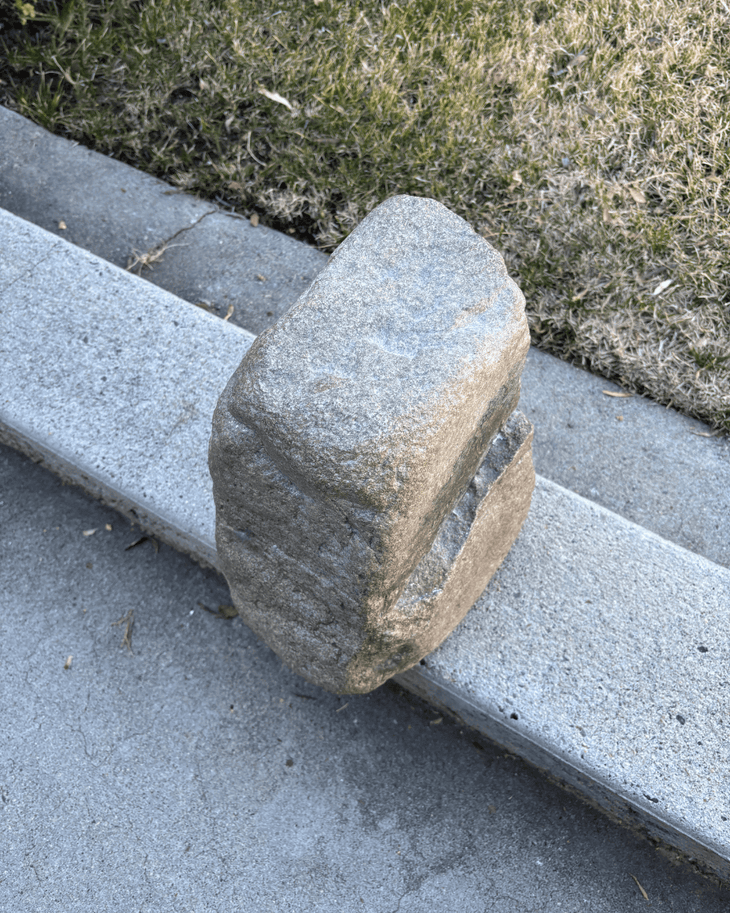 The 70-pound rock called Portable on a roadside curb.