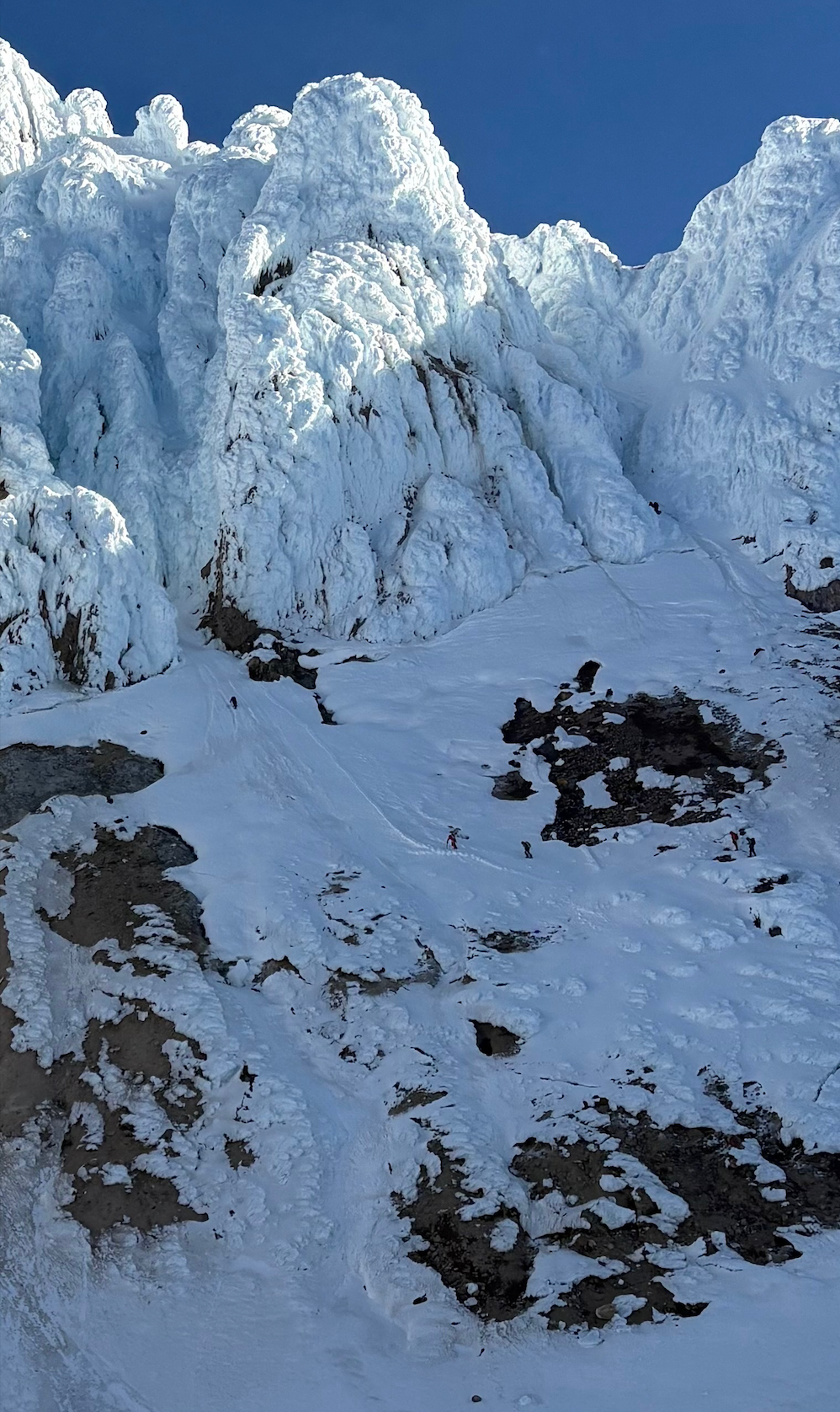 Four climbers ascend snow on Mount Hood, shortly before a novice climber dies free soloing.