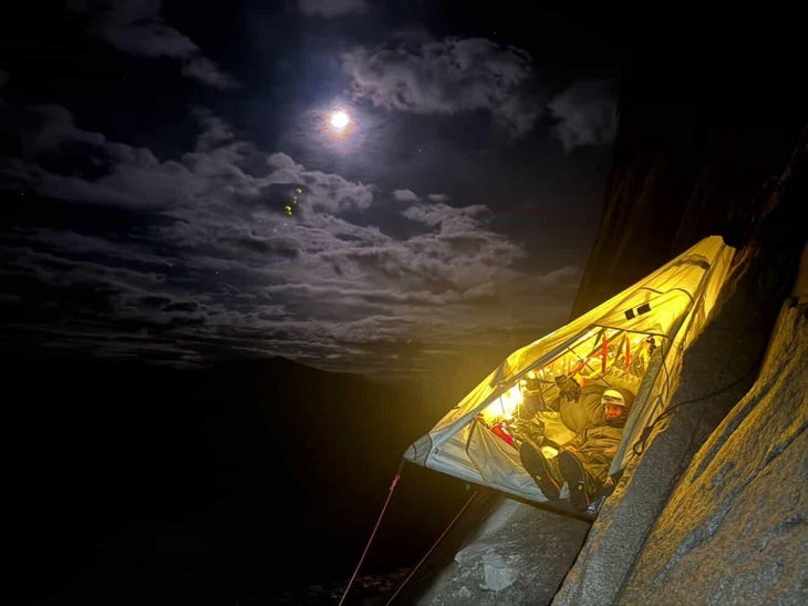 Climber in portaledge camp under a full moon.