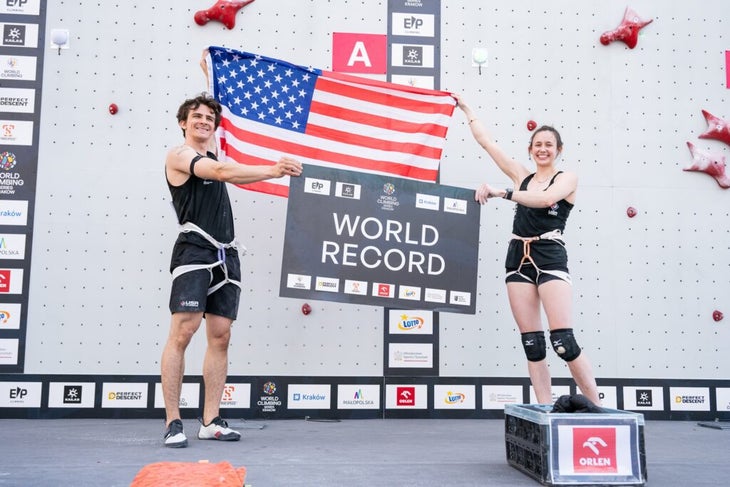 Sam Watson and Emma Hunt hold up a world record sign, shortly after Hunt made a new women's speed climbing record