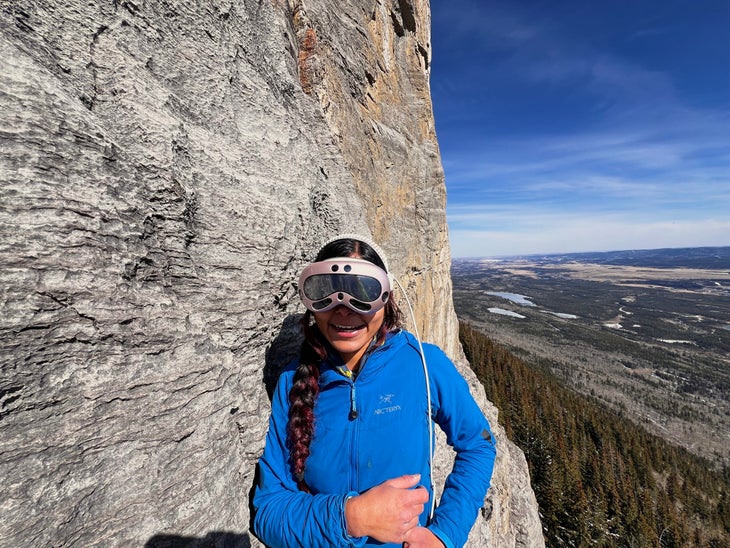 A woman wearing AR glasses while climbing