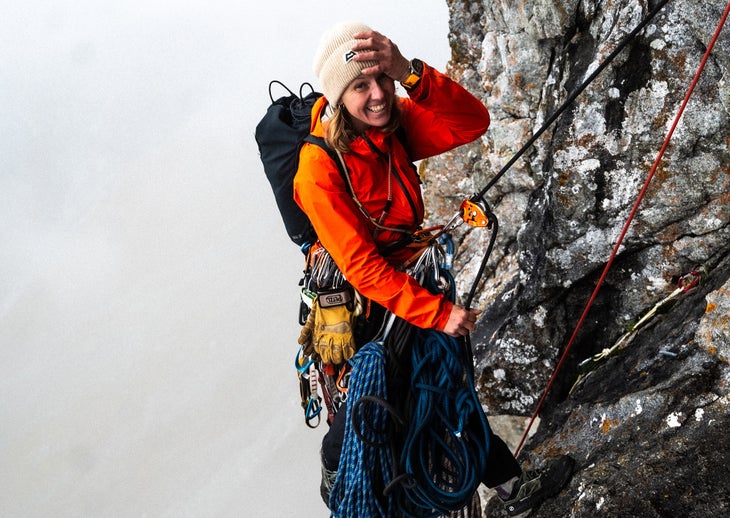 Aleksandra Taistra multi-pitch climbing, hanging from an anchor with a rope