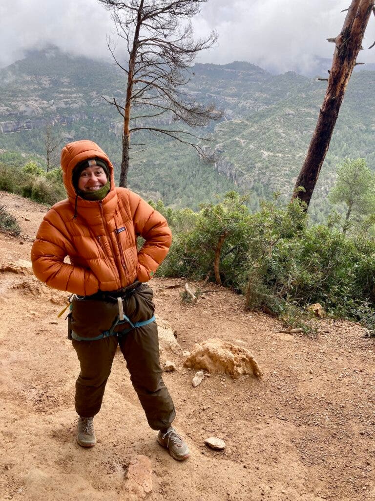 a girl at a crag in a puffy jacket