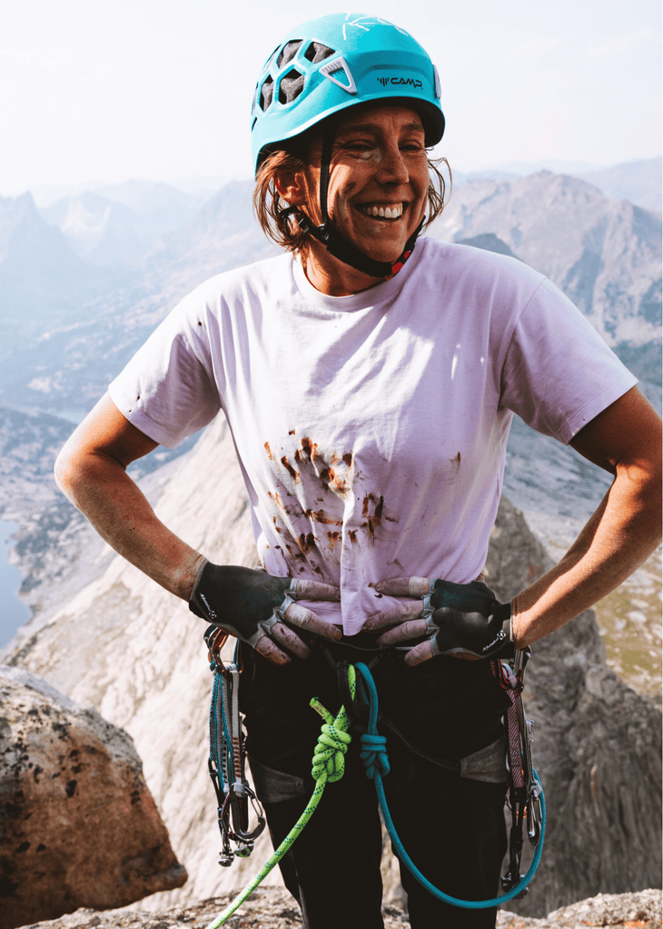 Amity Martine stands on top of cliff with blood staining her t-shirt.