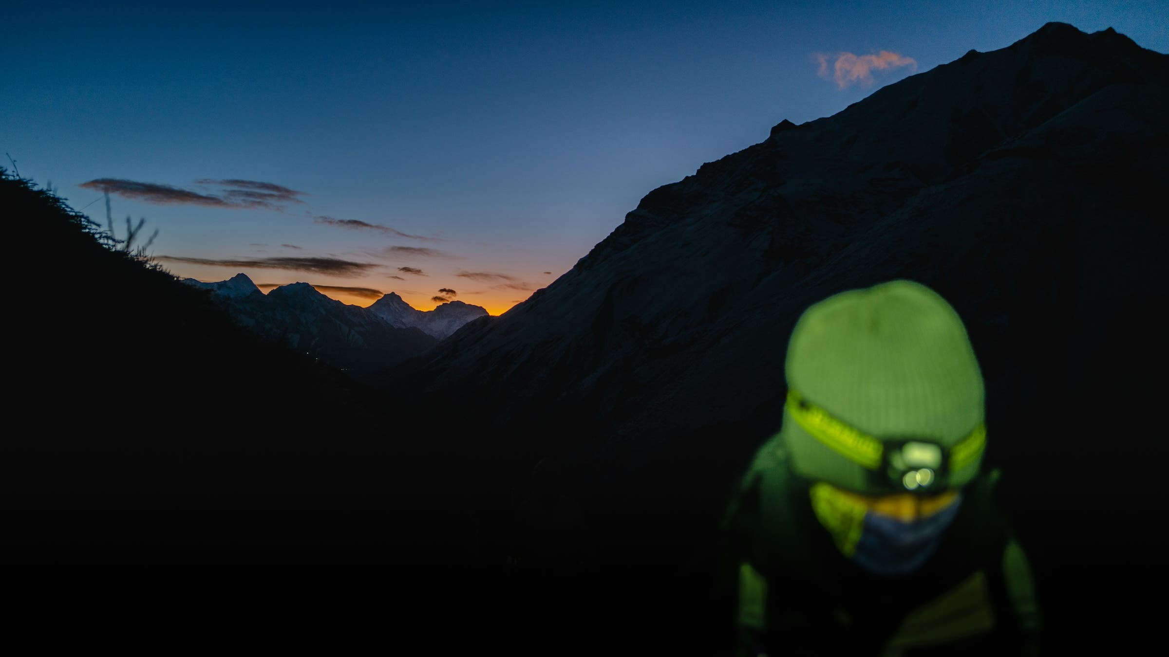 benighted: a climber with a green hat and headlamp