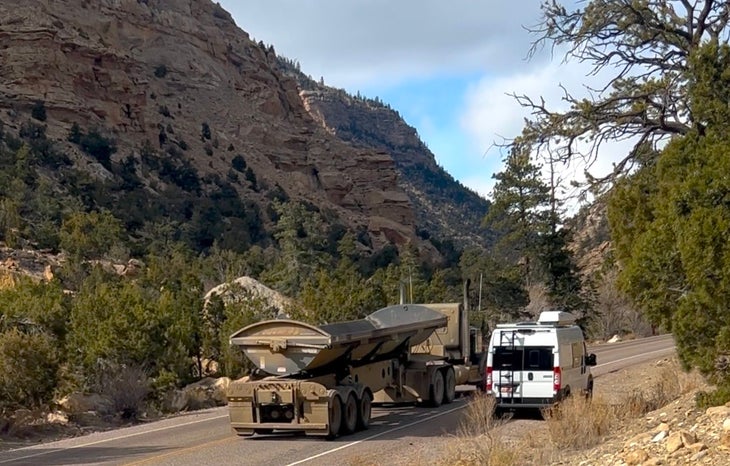 A coal truck passes a van
