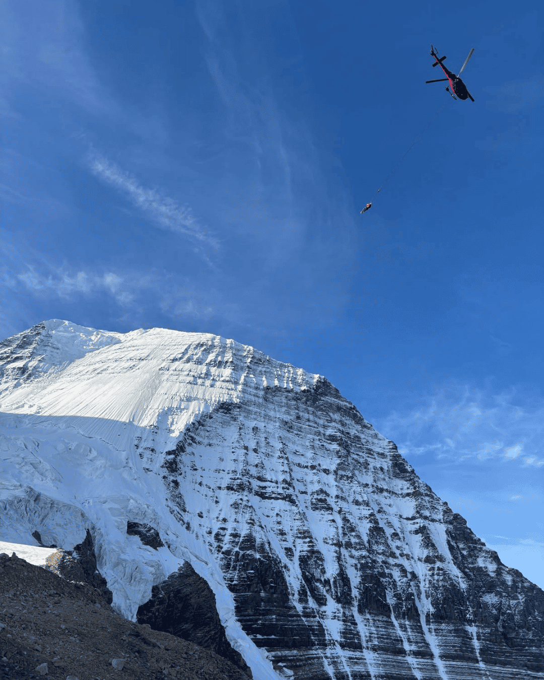 helicopter long lines a rescue toward a steep mountain face