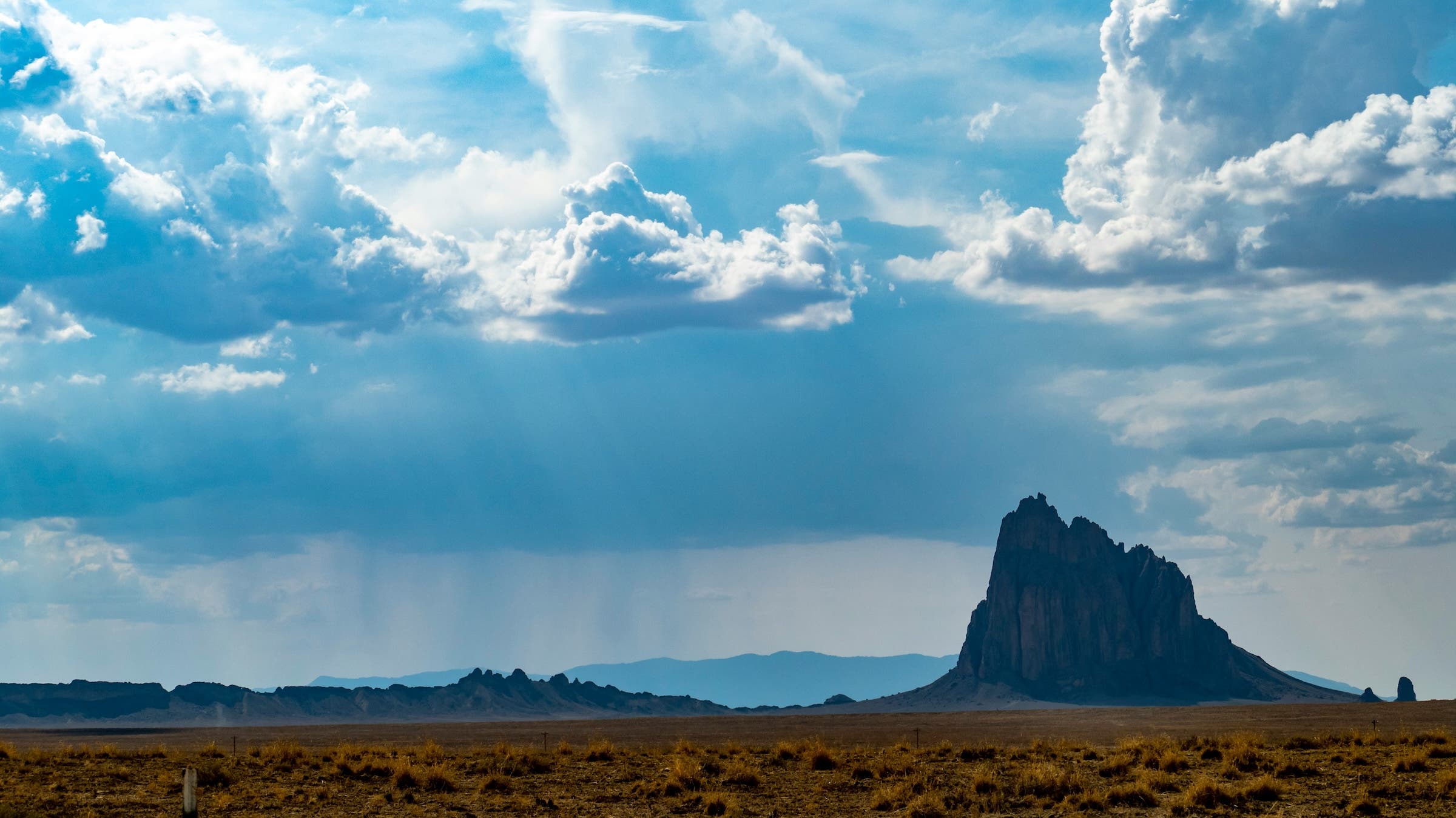 where to climb this winter with el nino: rock, ice, and alpine. in this photo, rain clouds can be seen in the distance by a monolith.