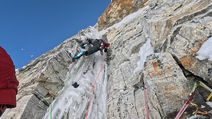 man climbers vertical rock in nepal in crampons