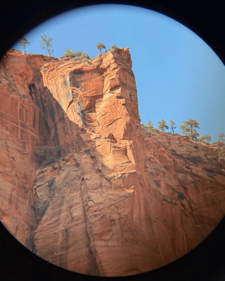 climbers top out a sandstone cliff