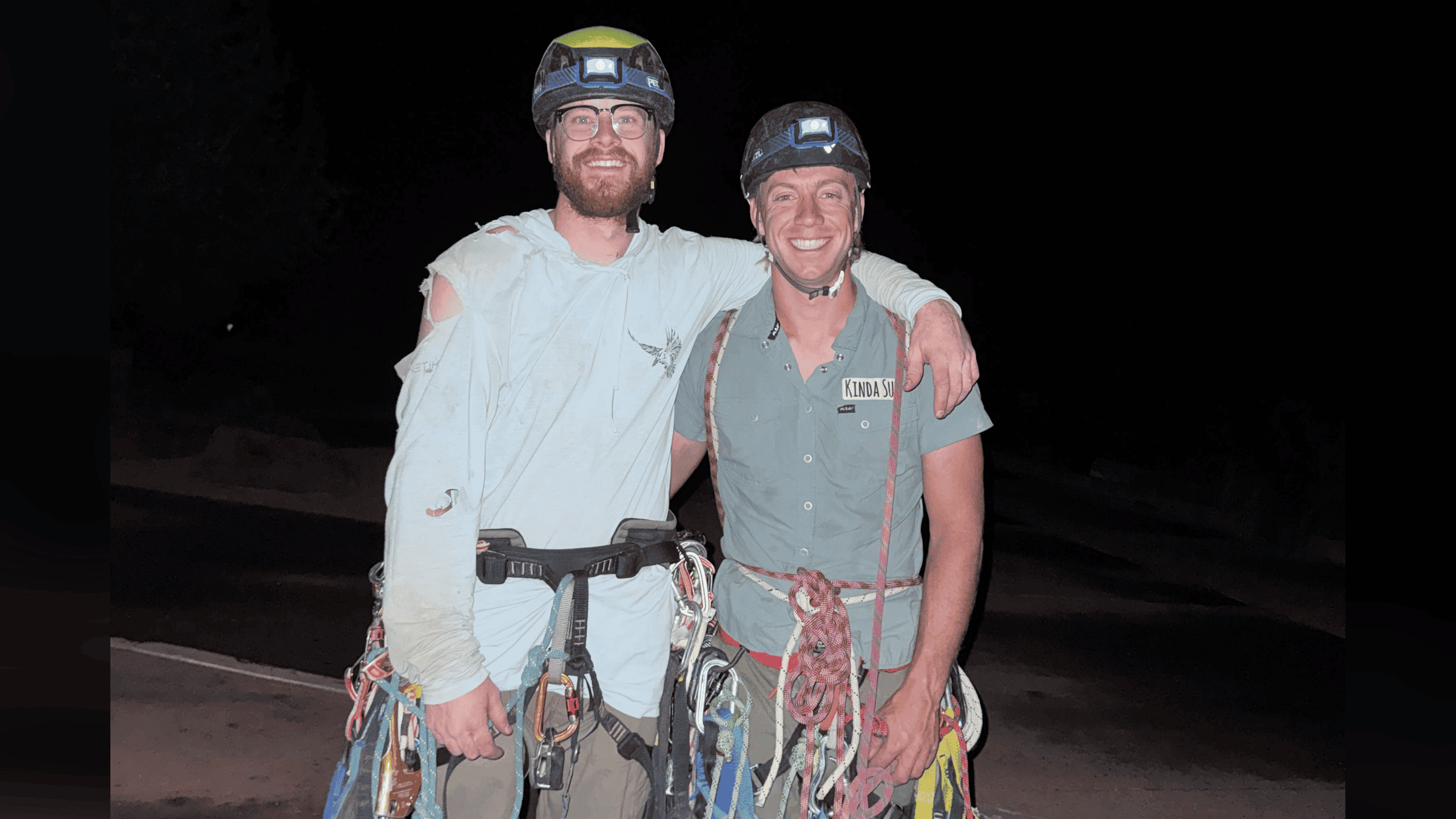 two Climbers smile in the dark after making History in Zion, Utah